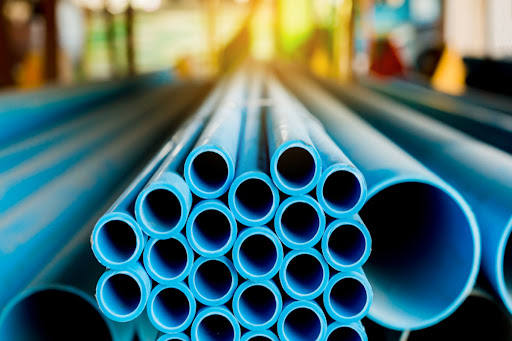 Blue PVC pipes stacked on top of one another.