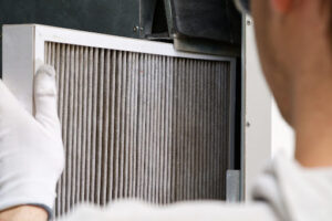 A person replacing a furnace filter.