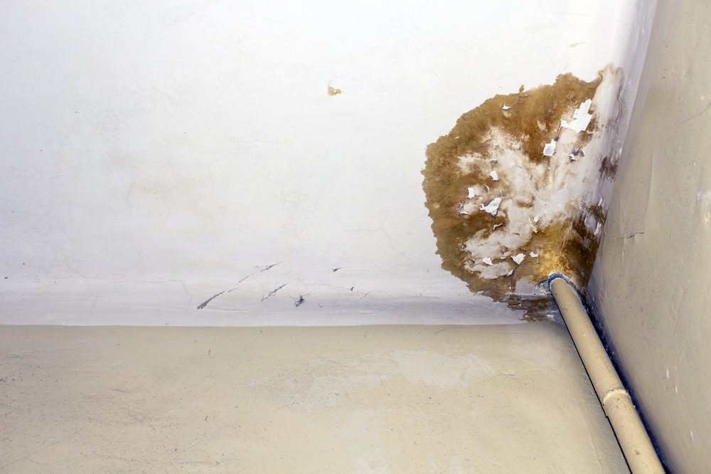 old plumbing pipe that is leaking water and leaving a stain on the ceiling
